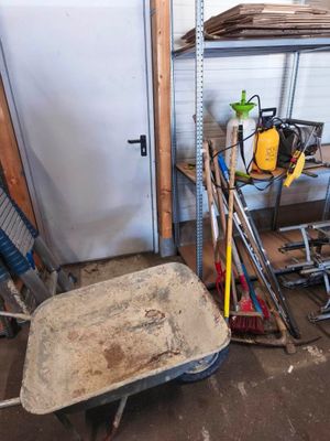 une brouette au milieu d'une pièce remplie d'outils