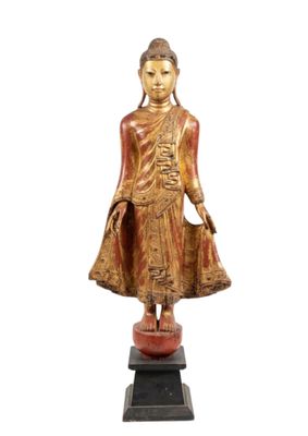 statue en bois représentant un Bouddha debout sur un socle, sur fond blanc