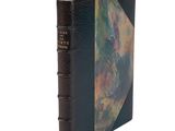 an old book with a black cover and a painting on it