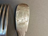 a silver fork and a silver spoon on a table