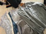 a pile of clothes on the floor next to a suitcase