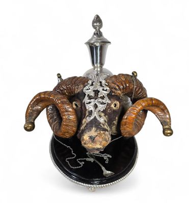 a silver and black object with a ram head on it