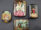 trois petites boîtes en fer-blanc ornées de peintures, posées sur une table