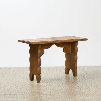 a small wooden bench on the floor in a room