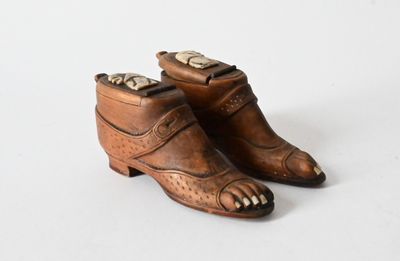 pair of antique brown leather shoes with gold accents on white background