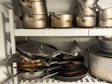 many pots and pans on the shelves in the kitchen