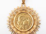 a close up of a gold medal with a woman ' s face on it