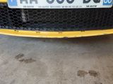 a close up of a yellow car with a license plate on it
