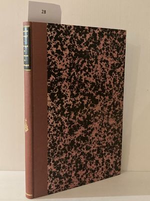 le livre est posé sur une étagère blanche, avec une couverture marron