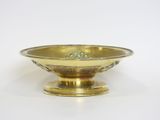 a gold bowl on a stand on a white surface
