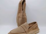 une paire de pantoufles en daim pour homme sur fond blanc