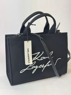black tote bag with white writing on it and a tag on the side