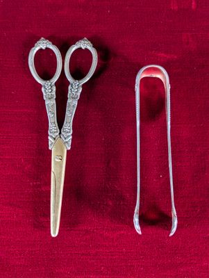 deux paires de ciseaux posées l'une à côté de l'autre sur un tissu rouge