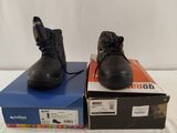 two pairs of black shoes sitting on top of boxes on a white surface