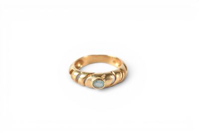 an image of a gold ring with a green stone
