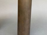 a close up of a brass vase on a gray surface