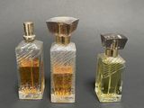 three bottles of perfume sitting next to each other on a table