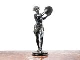 une statue représentant une femme tenant un éventail, posée sur une table