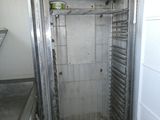 une image représentant une toute petite pièce avec une porte métallique