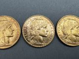 three gold sovereigns, one of which is a woman and one of which is a man