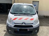 La petite camionnette est garée devant un garage.