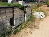 a concrete wall with a green roof on the side of the road