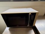 un micro-ondes posé sur une table près d'une fenêtre
