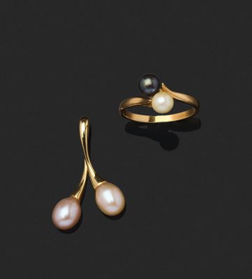une paire de boucles d'oreilles en perles et une bague en or sur fond noir