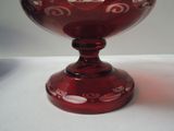 a red glass bowl sitting on a white table