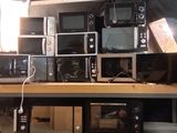 de nombreux micro-ondes et grille-pain posés sur une étagère dans une pièce
