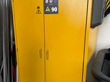 une armoire jaune dans un garage, à côté d'une poubelle noire