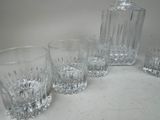 four glasses and a decanter sitting on a table