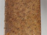 an old book sitting on top of a white surface