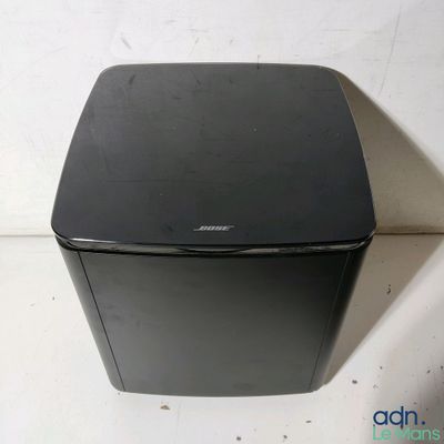 une petite boîte noire posée sur une surface blanche