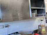 une cuisine avec des placards et des plans de travail en acier inoxydable