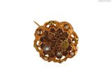 une photo en gros plan d'une broche ornée d'un motif floral