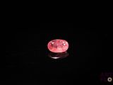 un diamant rose sur une surface noire dans l'obscurité