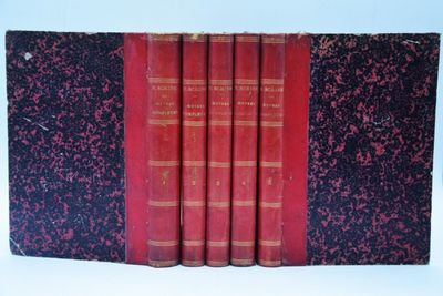quatre livres rouges sont alignés sur une surface blanche