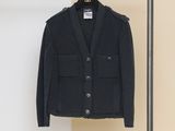 a black jacket hanging on a clothes rack next to a wall