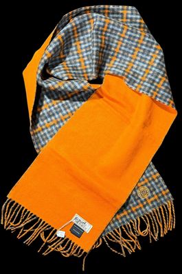 an orange scarf with a checkered pattern and a tag on it