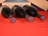 four bottles of wine in a wooden box on a red cloth