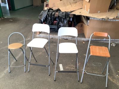 several chairs and stools are sitting in a garage area