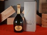une bouteille de champagne posée sur une table à côté d'un coffret