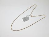 un collier muni d'une étiquette, posé sur une surface blanche