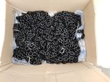 une boîte en carton contenant un tas de pelotes de laine noire et blanche