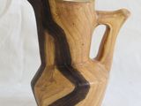 a wooden vase that is sitting on a white surface