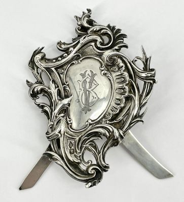 une assiette en argent sur laquelle sont représentés un couteau et un bouclier