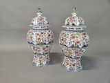 two vases with birds and flowers painted on them on a gray surface