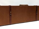 a brown suitcase sitting on top of a white table