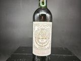 une vieille bouteille de vin posée sur une boîte noire